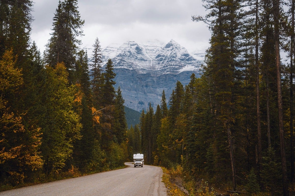 A mountain highway, with The Dyrt RV Trip Planner route on a phone